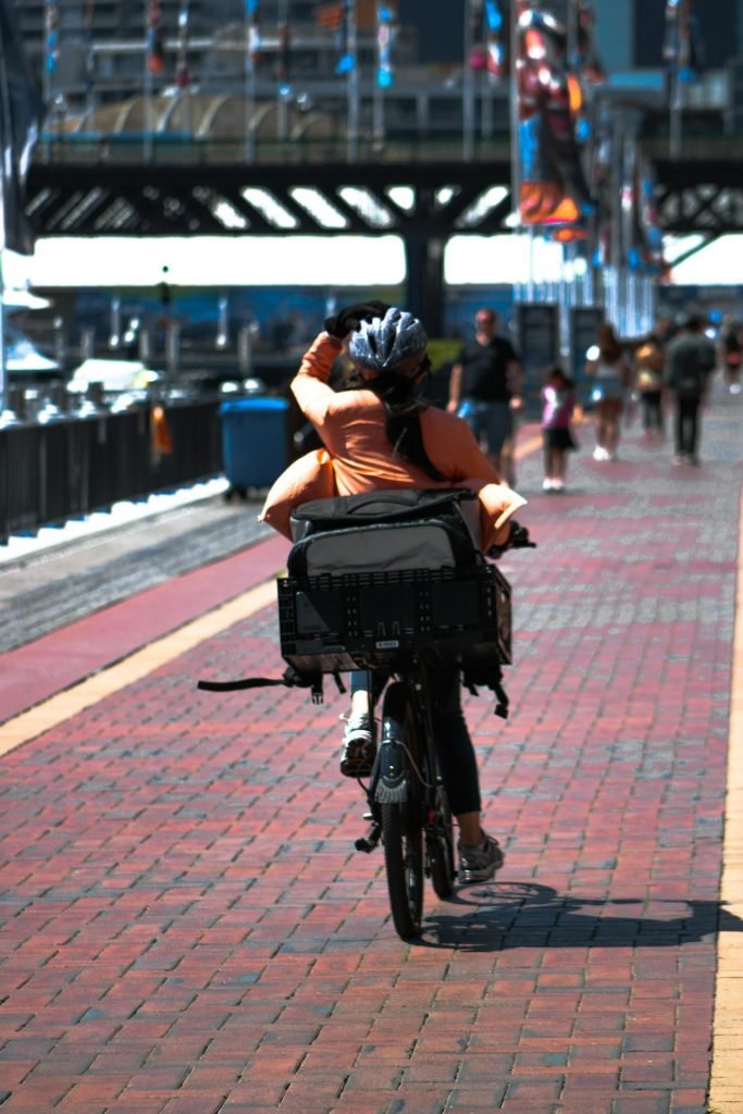 woman-in-black-jacket-riding-on-black-bicycle-on-road-during-daytime-paxwkyeuyi0